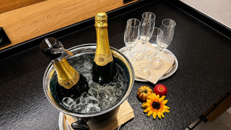 Sektflaschen auf Eis mit Gläsern am Frühstücksbuffet im Hotel Bercher