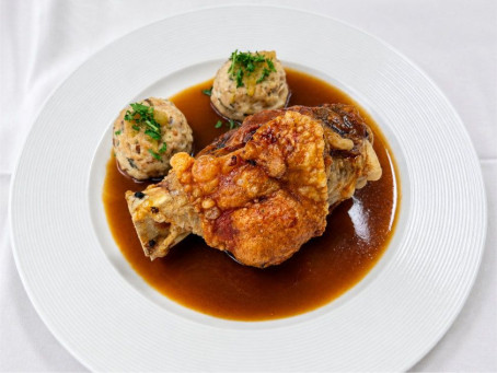 Knusprige Schweinehaxe mit Beilagen im Restaurant des Hotel Bercher